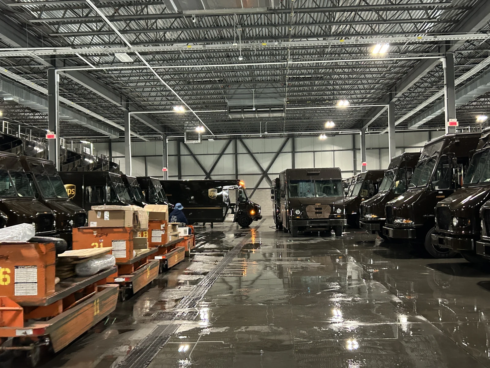 Moving irregular packages. A PIT vehicle and irregular-package carts passing the metro area on the hub floor.